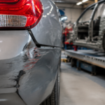 Parte traseira de veículo com danos aparentes após pequena colisão, enquanto a estrutura automotiva é avaliada em oficina especializada, destacando riscos de danos ocultos e a importância da inspeção estrutural após acidentes leves.